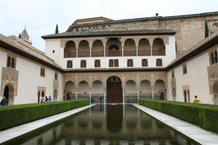 Alhambra – Patio de Arrayanes. Bassinet er omkranset af myrtehække, og buerne spejler sig i vandet. 
