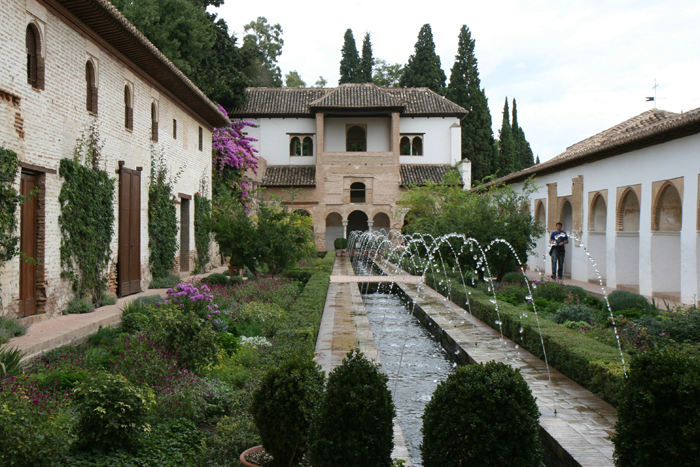 Generalife – Patio de la Acequia. Gårdhaven er anlagt omkring et langt bassin, hvorover rækker af vandstråler danner fine buer. Flot haveanlæg. 