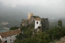 Det lille klokketårn og den gamle borg Castell de Guadalest på toppen af klipperne i byen Guadalest. Til venstre i billedet skimtes den store inddæmmede sø.