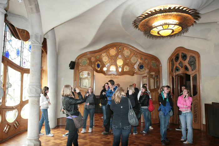Den store dagligstue i Casa Batlló med udsigt til gaden. Loftet er pudset op i spiralform og dørene samt vinduesrammerne bølger festligt.