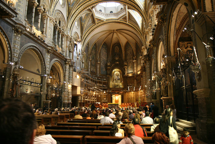Basilikaen i Monestir de Montserrat. Sanktuariet i den kuplede basilika er udsmykket med et rigt emaljeret alter. Over alteret ses den lille træfigur La Moreneta (den sorte jomfru).