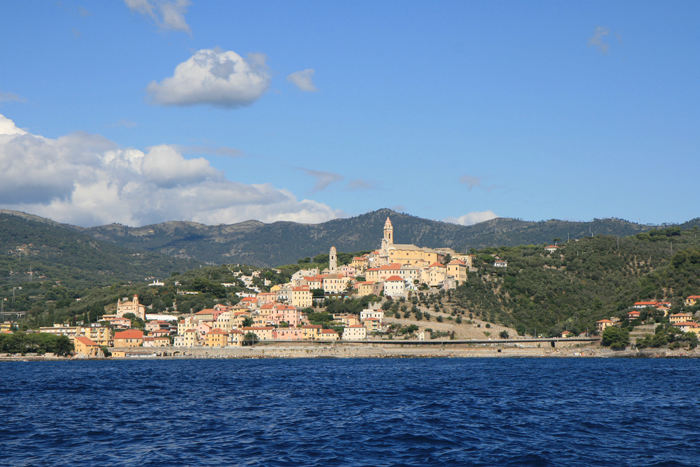 San Lorenzo al Mare set ude fra vandet. Efter, vi er kommet til Italien, er bjergene kommet helt ud til kysten, og byerne ligger klistret op ad bjergskråningerne.  