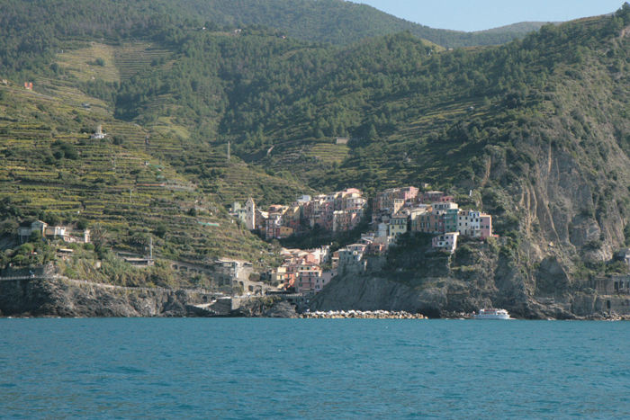 Cinque Terre byen Manarola set ude fra vandet. Læg mærke til terrasserne bag byen, hvor der dyrkes en speciel Cinque Terre vin.
