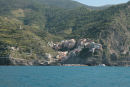 Cinque Terre byen Manarola set ude fra vandet. Læg mærke til terrasserne bag byen, hvor der dyrkes en speciel Cinque Terre vin.