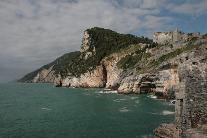 Klippekysten uden for Portovenere op mod Cinque Terre. Oppe på toppen af klipperne ses Castello Doria, der ligger højt hævet over byen. 