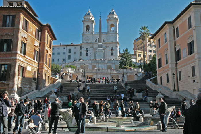 Piazza di Spagna med Den Spanske Trappe og i baggrunden kirken SS. Trinità dei Monti. I forgrunden en fontæne i form af et halvt sunket skib.  