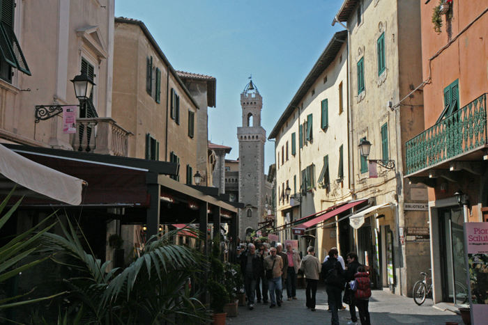 Rådhuset med klokketårnet i Piombino og den smalle gade Corso Vittorio Emanuele med alle restauranterne.