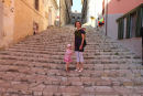 Gaderne i Portoferraio er meget stejle, og de fleste steder er der store trapper. Her er Maiken med Kasper på ryggen og Julie på vej op mod toppen. (Foto Jakob)