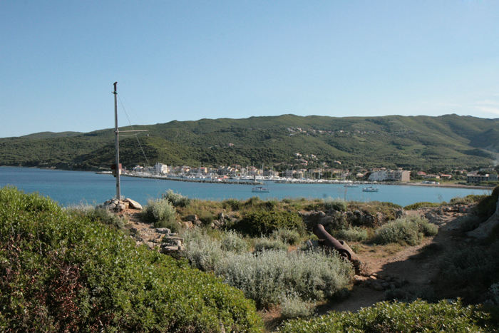 Et noget forfaldent mindesmærke på det sted, hvor nationalhelten Pascal Paoli gik i land i 1790 efter flere års eksil i England. I baggrunden Macinaggio med en flot ny marina.