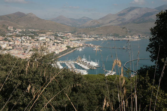 Udsigten oppe fra Monte Orlando ned over havnen i Gaeta og den østlige bydel. Byen og havnen ligger inde i en bugt omkranset af flotte bjerge.