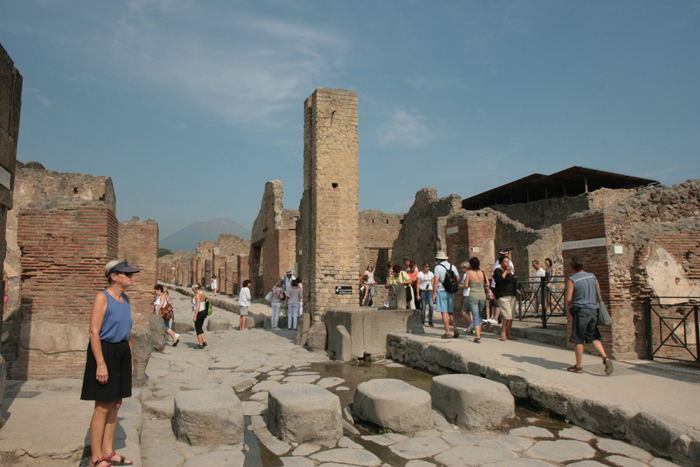 En typisk gade i Pompeji. Stenene tværs over gaden er den tids fodgængerfelt. Så kunne man gå tørskoet over vejen. Man havde standardiseret hjulafstanden på vognene, så de kunne passere. 