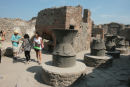 Kornmøllerne, der blev trukket rundt af slaver eller æsler, i et af de mange bagerier i Pompeji. I baggrunden ses bageovnen.