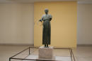Delfi Arkæologiske Museum. Den unge vognstyrer står fastfrosset i bronze, blikket er rettet fremad, og højre hånd holder løst i tømmerne. Statuen vidner om Delfis pythiske lege.