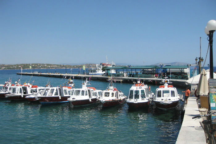 Taxibådene i Spetses fortøjer uden på hinanden, og når der kommer kunder, stiger de ombord i den inderste, som så sejler, og de haler så hele rækken ind til kajen og er klar til næste kunde. 