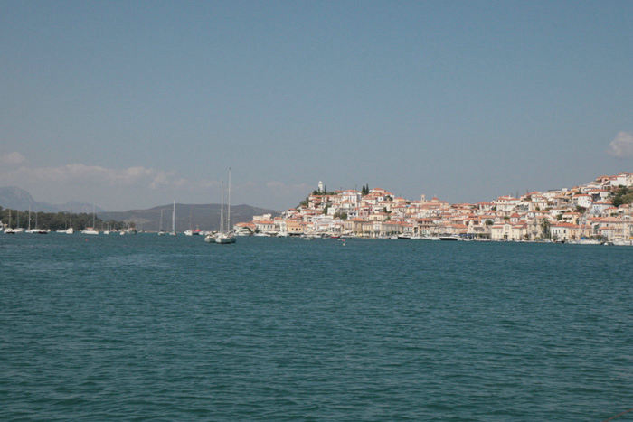 Vi er nu nået til Poros og sejler gennem det smalle sund mellem Poros og Galatas. Det er Poros by til højre i billedet.
