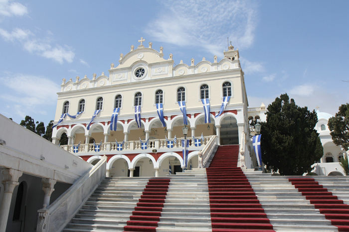 Bebudelseskirken Panagia Evangelistria i Tinos by med den røde løber, som pilgrimmene kravler op ad på deres knæ. Der er lagt en rød løber ned i asfalten helt nede fra havnen og op til kirken.