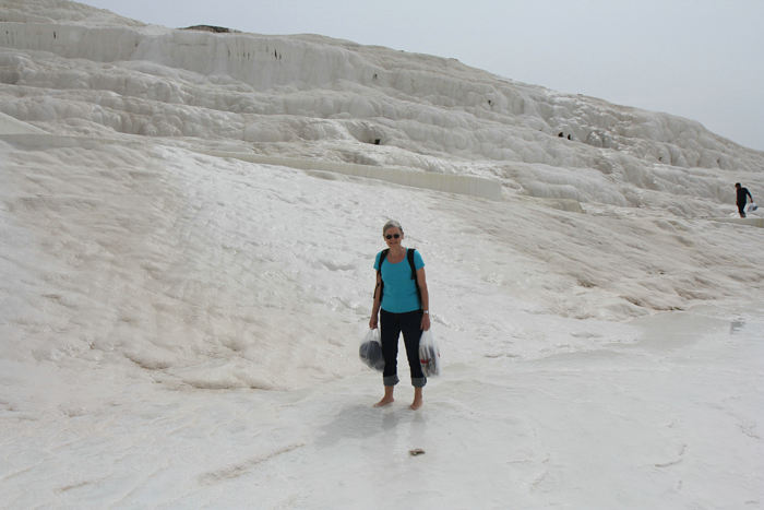 Inge Lise på vej op ad kalkterrasserne i Pamukkale med fodtøjet i plastikposer. Vandet var dejligt lunt til at begynde med, men blev køligere, jo nærmere vi kom tilløbet på toppen. 