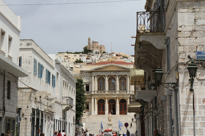 Eleftheriou Venizelou gaden, der går nede fra havnen i Ermoupolis på Siros og op til torvet med rådhuset. I baggrunden ses Saint George’s katedralen i Ano Siros.