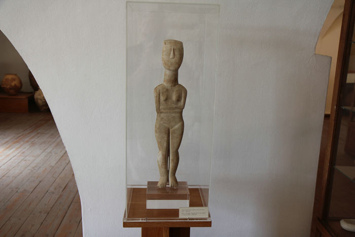 Kvindestatuette med foldede arme er typisk for kykladerne. Hovedet er kastet lidt bagover. En af mange figurer på det Arkæologiske Museum i Naxos.  