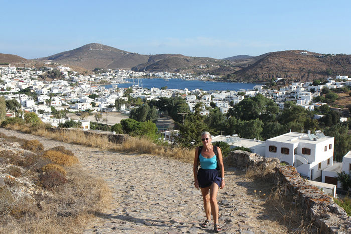 Skipperinden på vej op ad den gamle stenbelagte vej, der fører fra havnen og op til Chora og klosteret på Patmos. I baggrunden havnen i Skala. 