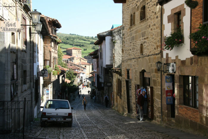 Calle Canton, en af hovedgaderne i Santillana del Mar. I baggrunden skimtes det gamle kloster og Colegiata kirken.