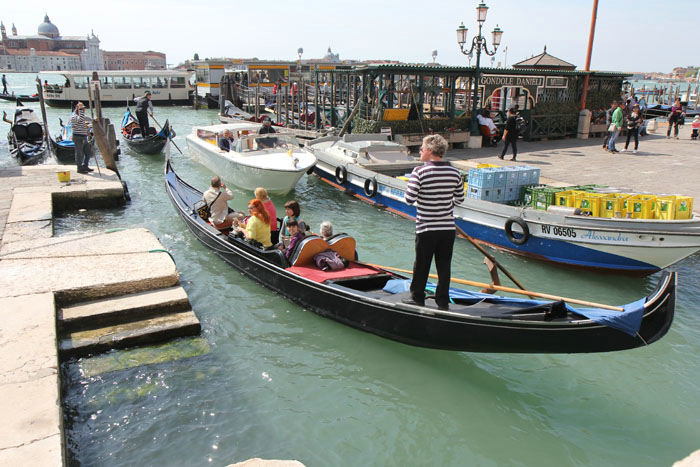 Der er en livlig trafik i de snævre kanaler i Venedig. Her en fragtbåd, en motorbåd og nogle gondoler, der skal passere hinanden.