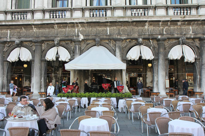 På San Marco pladsen er der flere fornemme caféer. Her Caffè Florian, hvor prisen er tårnhøj, og hvis musikerne spiller, bliver der lagt 40 kr. på hver kop kaffe.   