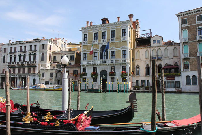 Flot udsmykkede gondoler i forgrunden. I baggrunden nogle af de flotte palæer langs Canal Grande i Venedig. 