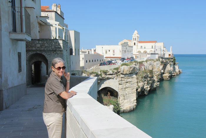 Skipperinden nyder udsigten ud over Adriaterhavet fra den gamle bydel i Vieste. I baggrunden San Francesco kirken.