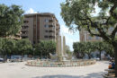 Den flotte skulptur på Piazza Cairali i Brindisi. Brindisi er en gammel by med smalle stejle gader, men midt gennem byen går et par brede gader med træer langs siden.