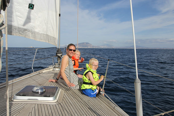 Vi var heldige at få en smule vind til turen fra Favignana til Trapani, og det lykkedes at gennemføre turen for sejl alene, men det tog sin tid. Maiken, Julie og Kasper nyder turen på fordækket. (Foto Jakob)