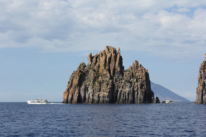 Basiluzzo klippen, der ligger mellem Panarea og Stromboli, der skimtes bag klippen.