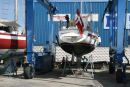 Så er vi klar til søsætning. Skipper er ved at male der, hvor stativet har støttet båden. Læg mærke til de ’beskyttere’, de har monteret på stropperne, for at beskytte fribordet