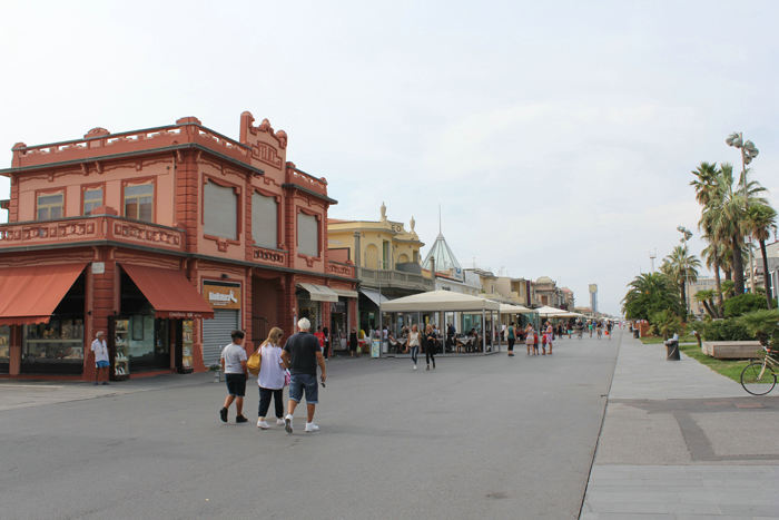 En anden side af Viareggio. Der er en kæmpe strand nord for havnen med tusinder af parasoller og liggestole. Her gaden, der går langs stranden, med restauranter, spillekasinoer og mange andre forlystelser. 