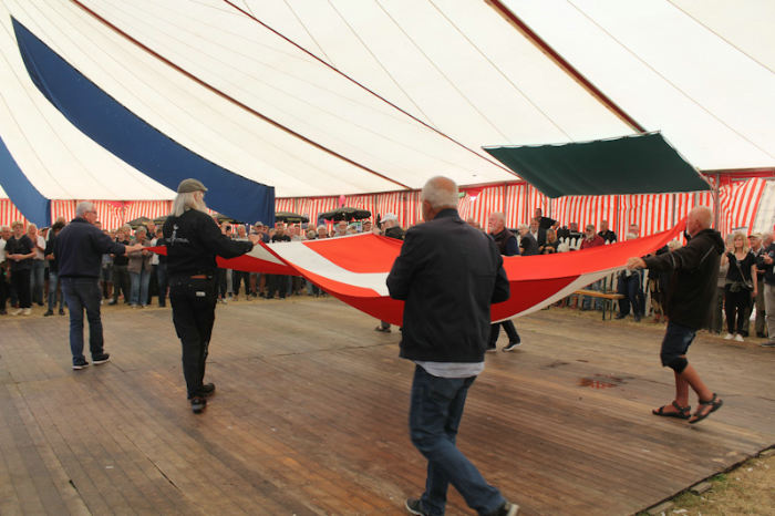 Den festlige afslutning på Tunø Festivallen, hvor det store flag, der er hejst, mens der er festival, bliver båret ind og lagt sammen, mens musikken spiller til.
