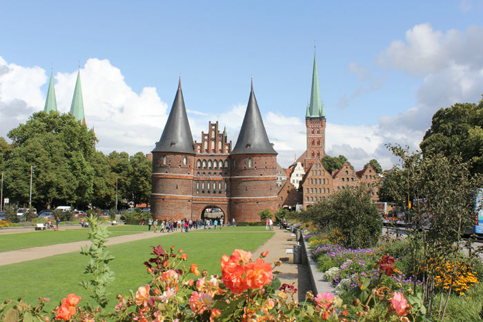 Holstentor i Lübeck med de store kirker i baggrunden.