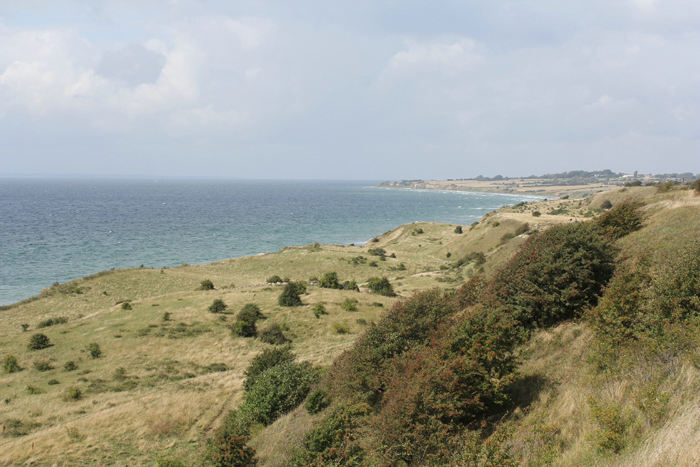 Voderup Klint på sydkysten af Ærø. Det er et specielt landskab, der åbner sig, når man står oppe på kanten af den 33 meter høje klint. Den ene terrasse afløser den næste på vejen ned mod stranden. 