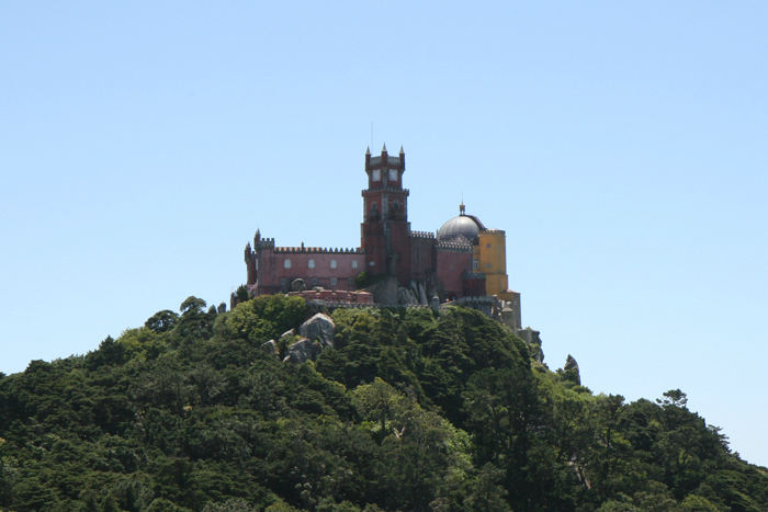 Pena National Palace set fra Castelo Mouros’ ringmur. Slottet ligger på den højeste bjergtinde og ser imponerende ud.  