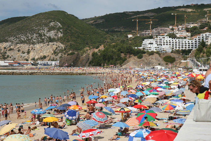 Sesimbra er en rigtig ferieby med masser af mennesker på stranden. Det ser festligt ud med alle de forskellige parasoller. 