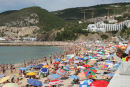 Sesimbra er en rigtig ferieby med masser af mennesker på stranden. Det ser festligt ud med alle de forskellige parasoller. 