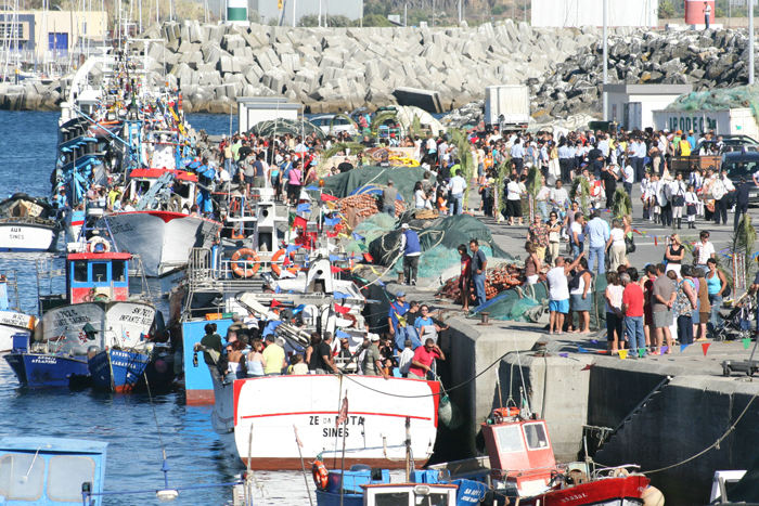 Alle fiskerbådene i havnen i Sines er pyntet i dagens anledning, og alle, der overhovedet kan være ombord, er det. Der er trængsel på havnen den dag, og bådene er nydeligt rengjorte. 