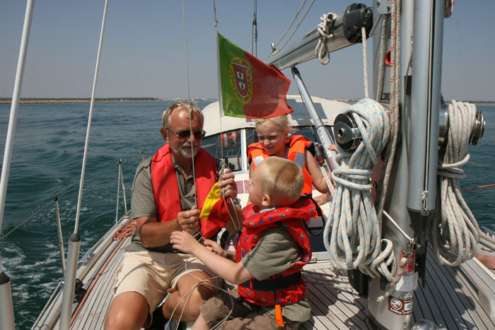 Skipper får hjælp af Marie-Louise og Christian til skift af gæsteflaget. Vi skifter det portugisiske flag ud med det spanske på vej til Isla Canela. (Foto Morten)