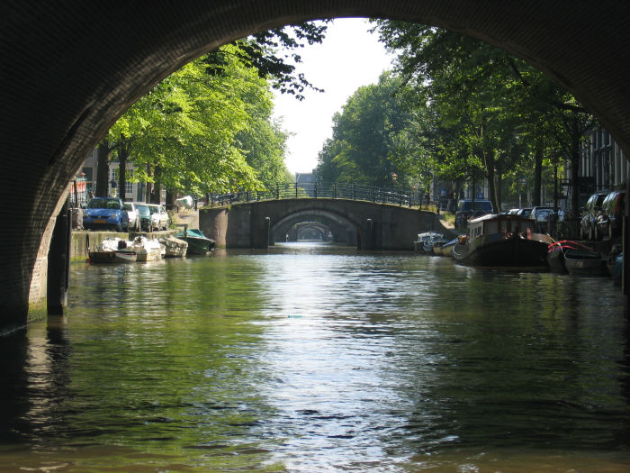 Der er mange kanaler i Amsterdam og en af de nemme måder at se Amsterdam på, er at tage en kanalrundfart. Her et kik op ad Reguliersgracht med de 7 buede stenbroer. 