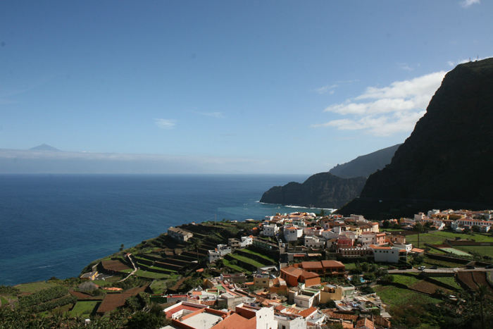 Agulo, en af de typiske små byer langs La Gomeras nordkyst. De ligger alle godt beskyttet nede i slugterne. I baggrunden ses Teide på Tenerife.