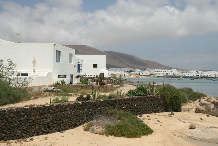 De fleste huse på Isla Graciosa er hvide med blå vinduer. Her nogle langs Avenida Virgen del Mar i Caleta del Sebo, lige ud til havnen.